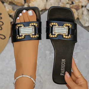 Elegantes sandalias planas negras con hebilla metálica dorada decorativa y patrón de cuadros