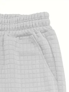 Close-up of white waffle texture shorts with elastic waist and side pocket details.