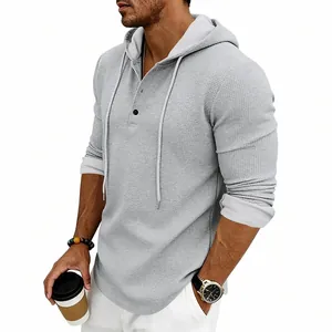 Side view detail of a men's grey waffle-knit hoodie showing the Henley button collar