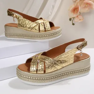 Macro view of gold croco-embossed platform sandals with elegant buckle charms