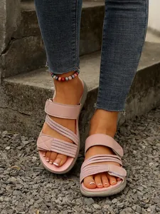 Vue détaillée de sandales de plage roses décontractées avec brides sur gravier gris