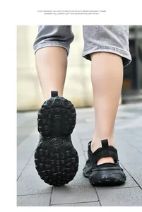 Vista trasera de zapatillas de malla negra transpirables para niños con detalle de la suela.