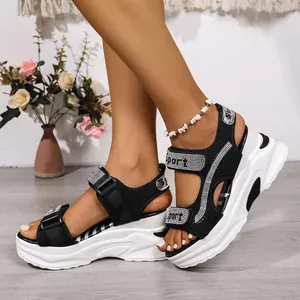 Dettaglio sandali neri platform con cinturini sportivi in strass e suola a zeppa bianca
