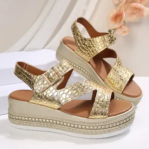 Detailed view of gold platform wedge sandals with crocodile texture and adjustable ankle strap