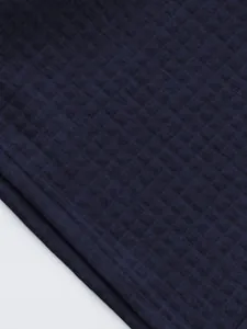 Macro view of navy blue quilted grid fabric texture for men's summer sports polo suit