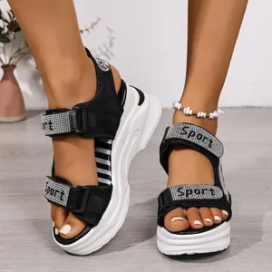 Dettaglio di sandali neri con zeppa alta, strass 'Sport' e chiusura in velcro