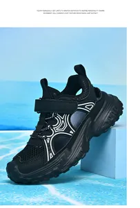 Detalle de zapatillas de malla negra transpirables para niños con diseño hueco y una suela blanda