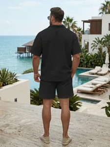 Back view of men's black waffle texture short sleeve polo and shorts set in luxury resort