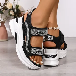 Dettaglio di sandali neri con plateau con cinturini Sport in strass e spessa suola bianca