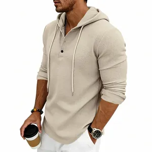 Close-up of men's beige waffle knit hoodie showing fabric texture and Henley neck.