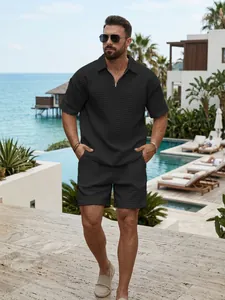 Macro view of men's black waffle texture half-zip polo and shorts set in resort setting
