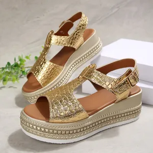 Detailed view of golden crocodile-textured platform sandals with studded wedge soles