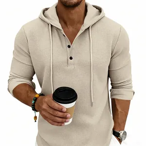 Detail view of men's beige waffle knit Henley hoodie with buttons and casual styling