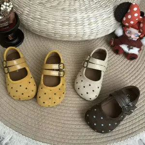 Vue détaillée de chaussures Mary Jane à pois pour filles aux couleurs chaudes.