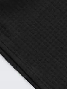 Close-up macro detail of black quilted texture fabric for men's casual polo sports set.