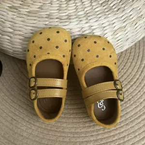 Vue rapprochée de chaussures Mary Jane jaunes à pois pour filles avec doubles brides