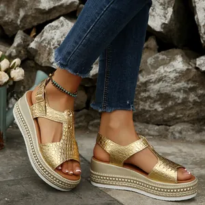 Detail view showing high-quality golden crocodile texture platform wedge sandals on feet.
