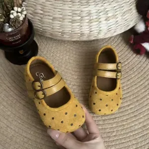 Détail de chaussures Mary Jane jaunes à pois avec doubles brides pour filles