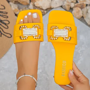 Vista detallada de sandalias planas amarillas para mujer con hebilla decorativa de metal dorado