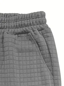 Close-up of grey waffle texture fabric on men's casual shorts with elastic waistband.