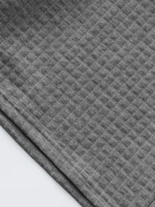 Detailed macro view of grey waffle-patterned breathable fabric for sports polo set