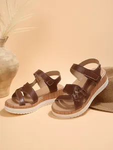 Detail view of brown wedge sandals with platform wood-grain sole