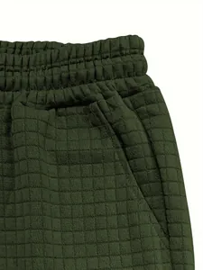 Detail view of dark green waffle knit shorts with elastic waist and side pocket