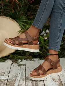 Close-up of brown platform wedge sandals with wood-grain texture and white sole