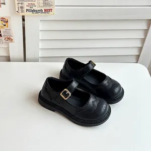 Élégantes chaussures Mary Jane noires pour filles avec détails perforés et boucle dorée.