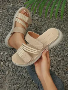 Vue détaillée des sandales de plage beiges pour femmes avec talons compensés et velcro.
