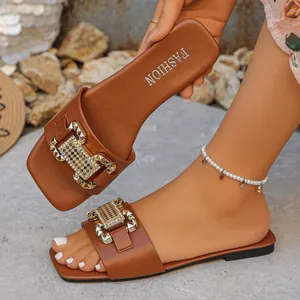 Sandalias planas de verano marrones para mujer con una hebilla metálica elegante