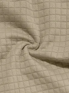 Close-up of breathable beige waffle textured fabric for men's casual polo sports set.