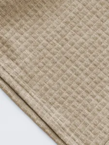 Detailed macro view of high-quality beige diamond quilted textured fabric for men's casual polo suit