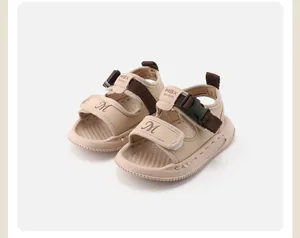 Close-up detail of beige toddler walking sandals featuring adjustable buckle and strap