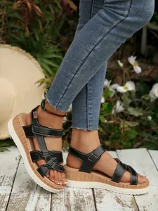 Detail of women's black platform wedge sandals featuring stylish wood-textured soles