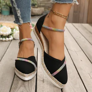 Detail van zwarte espadrilles met sleehak en puntige neus met kleurrijke regenboog strass-bandjes