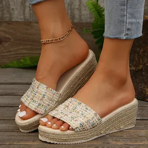 Primer plano de sandalias con cuña para mujer con tira de tweed y suela de cuerda