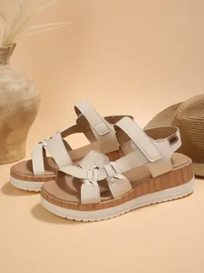 Detail view of beige platform wedge sandals with woven straps and wood grain sole