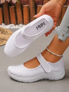 Close-up of white breathable mesh Mary Jane sneakers for women with velcro straps.