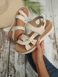 Detailed view of stylish cream wedge sandals with comfortable wood-grain platform soles