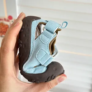 Dettaglio dell'estrema flessibilità dei sandali da spiaggia azzurri per bambini piccoli