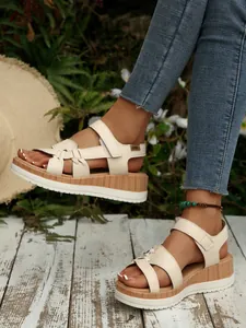 Detailed view of women's chic beige wedge platform sandals with woven strap design