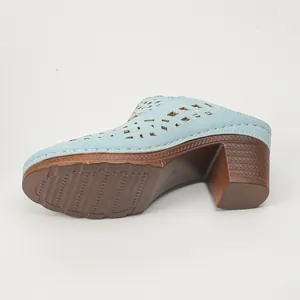 Detail view of light blue laser-cut chunky heel mule with anti-slip textured sole.
