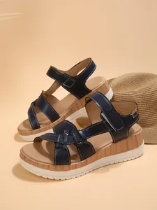 Detailed side view of navy blue leather platform wedge sandals with a sturdy white outsole