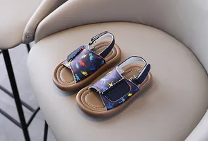 Detailed view of children's navy sandals featuring colorful dinosaur prints