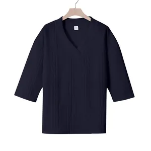 Detail eines marineblauen T-Shirts mit V-Ausschnitt und strukturierter Oberfläche.