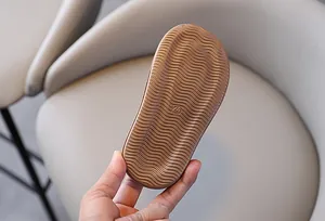 Close-up detail of the brown wavy anti-slip rubber sole on children's soft summer sandals