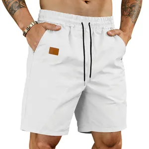Close-up of white quick-dry men's beach shorts with drawstring and patch