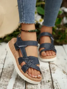 Stylish navy blue wedge sandals for women with Velcro straps and comfortable thick soles.