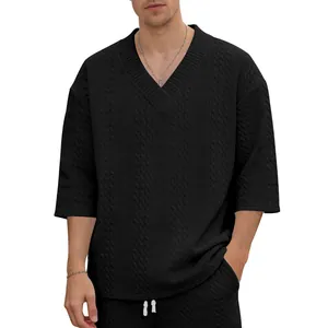 Detailansicht der Zopfstrick-Textur des schwarzen Herren-T-Shirts mit V-Ausschnitt